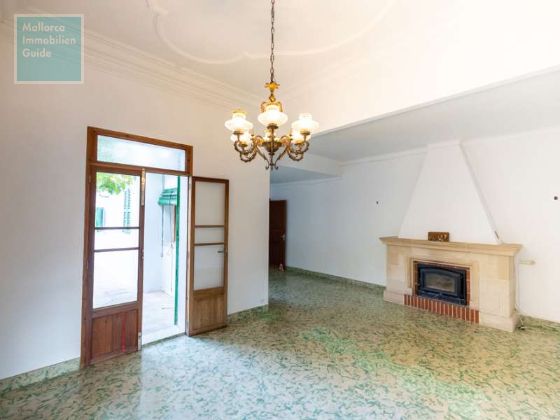 Wohnzimmer mit Kamin und Zugang zum Patio